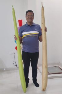 लौकी से लंबाई नापते लेखक - यह चित्र आठ फीट लंबी लौकी ने बनाई पहचान 